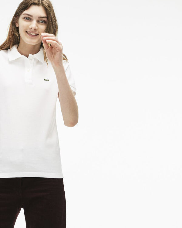 Front view of model wearing Lacoste classic 2 button relaxed fit polo in white with green alligator on chest