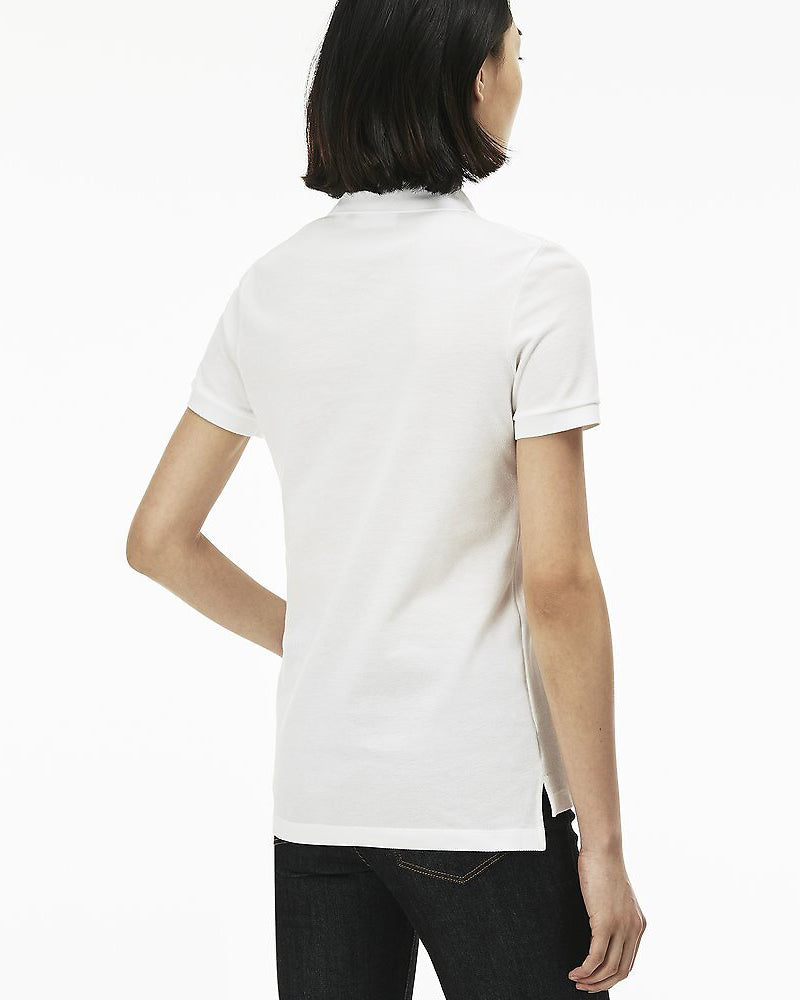 Back view of model wearing Lacoste classic 2 button relaxed fit polo in white with green alligator on chest