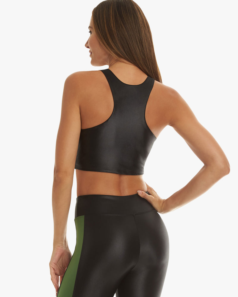 Back of model wearing black activewear sports bra and leggings with a green strip down the side seams